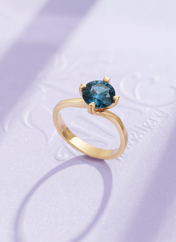 Natural Blue Topaz Twist Solitaire Ring in 14K Yellow Gold by AME Jewellery.
