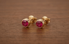 Boucles d'oreilles lunettes en or jaune 14K avec des rubis naturels par AME Jewellery.