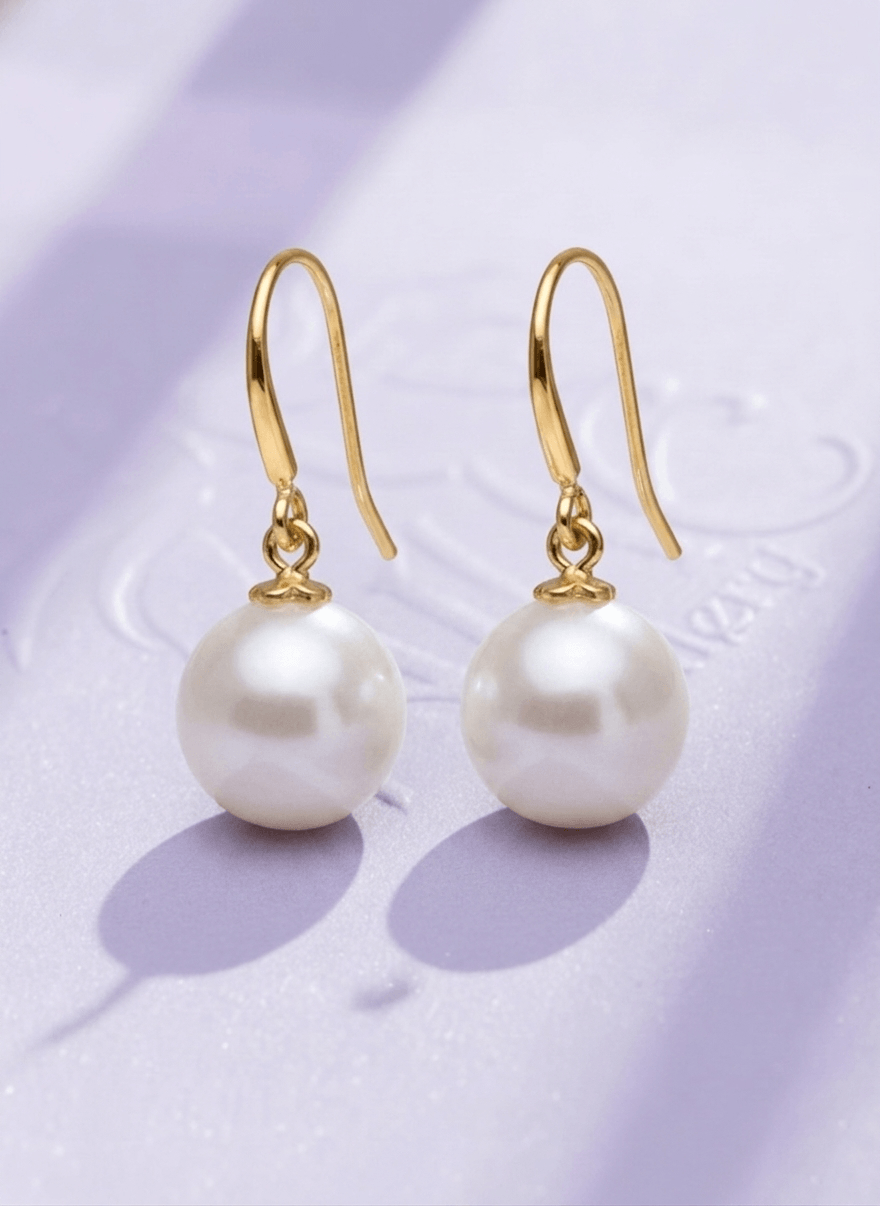 Boucles d'oreilles pendantes en or jaune 14K avec des perles de culture d'eau douce par AME Jewellery.