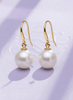 Boucles d'oreilles pendantes en or jaune 14K avec des perles de culture d'eau douce par AME Jewellery.